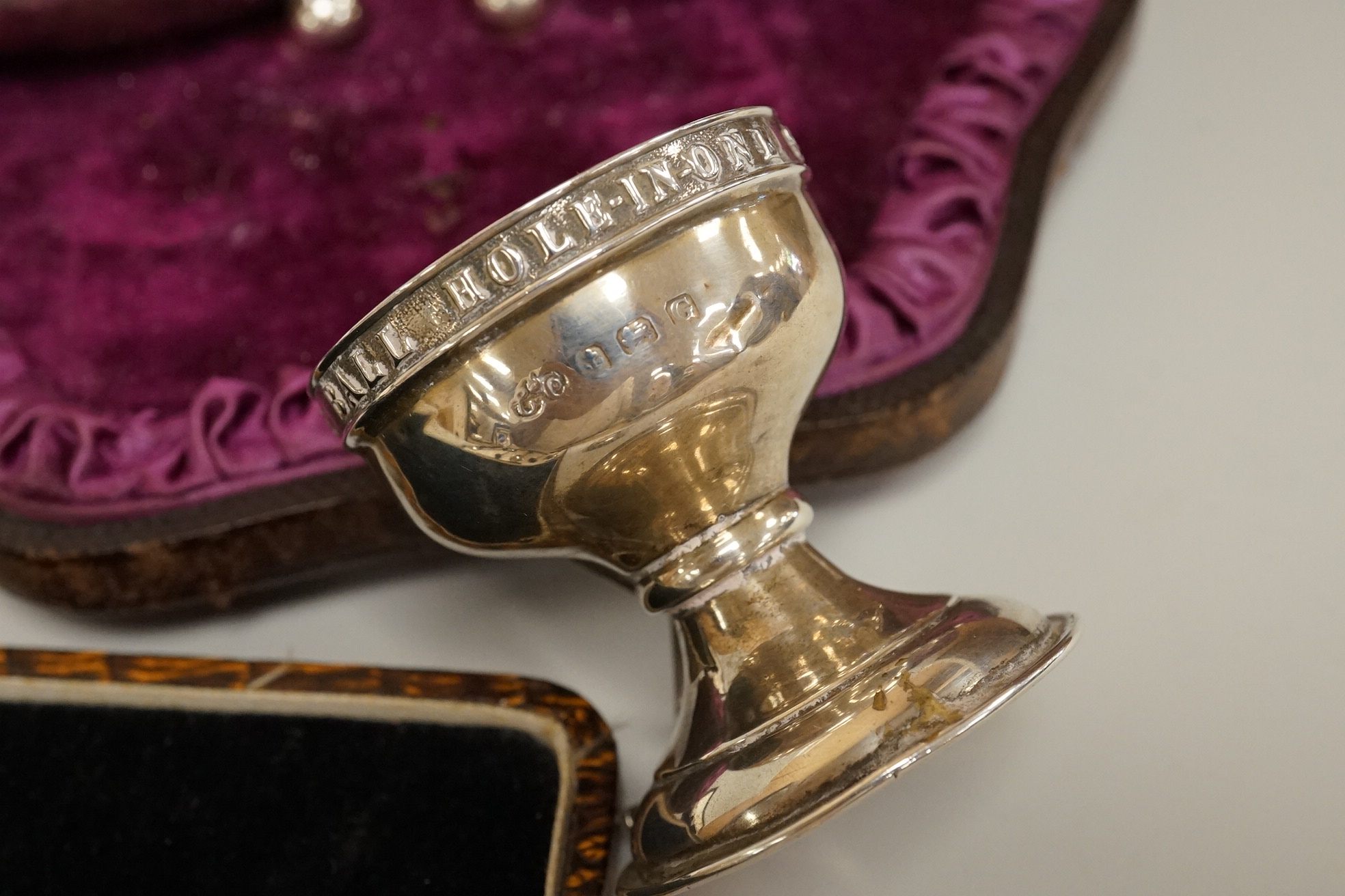 A cased pair of Victorian silver circular salts, by Edward Hutton, London, 1886, lacking spoons, together with a cased set of six silver bean end coffee spoons, a cased silver spoon, a small silver 'Dunlop Golf Ball Hole